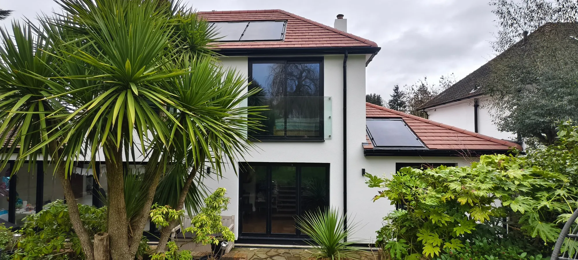 After: rendered house with first-floor rear extension, large glazing, Juliet balcony and solar roof, Lynwood Grove, Orpington